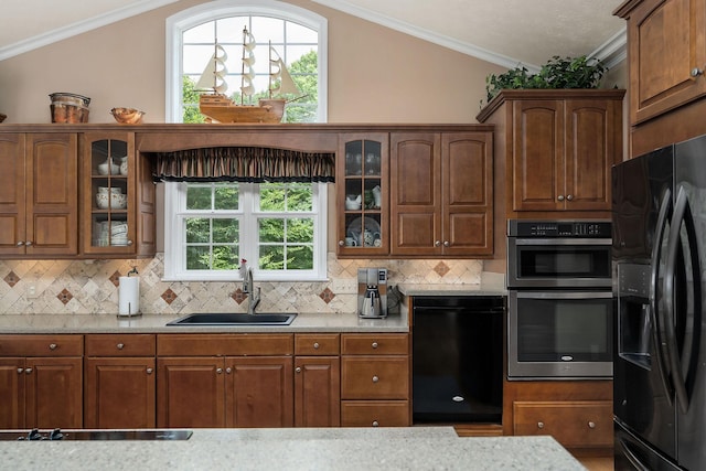 kitchen with lofted ceiling, sink, crown molding, black appliances, and backsplash