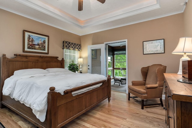 bedroom featuring ceiling fan, ornamental molding, a raised ceiling, and light hardwood / wood-style floors