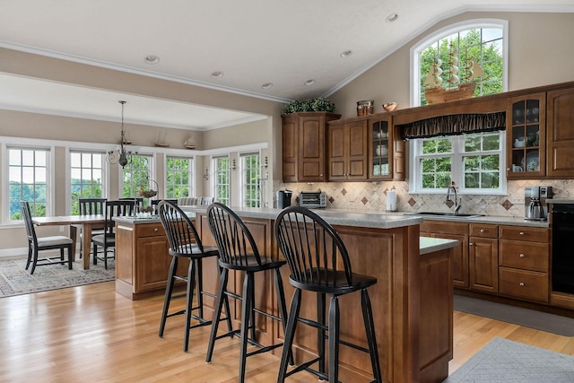 kitchen featuring a kitchen island, tasteful backsplash, sink, a kitchen breakfast bar, and hanging light fixtures