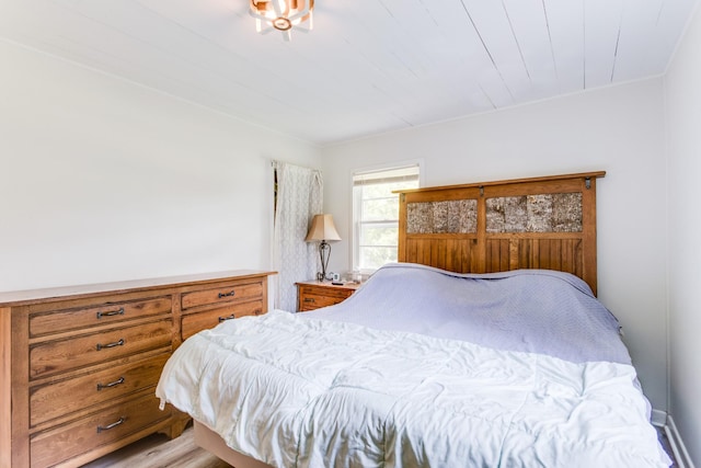 bedroom with light wood-type flooring and wooden ceiling