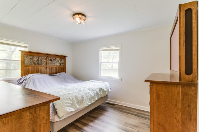 bedroom with dark hardwood / wood-style flooring