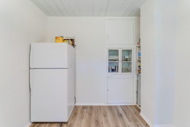 kitchen featuring light hardwood / wood-style floors, white refrigerator, and white cabinets