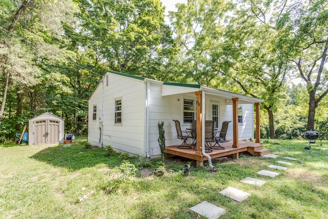 exterior space featuring a shed, a wooden deck, and a front lawn