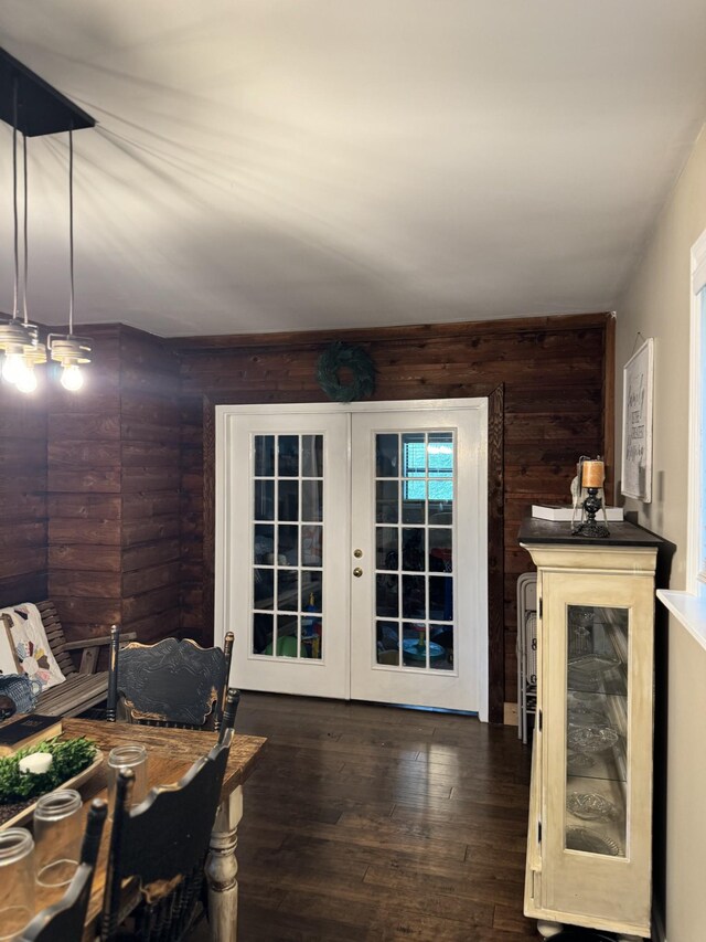 interior space with french doors, wooden walls, and hardwood / wood-style floors