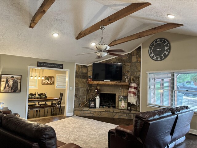 living room featuring hardwood / wood-style floors, a fireplace, ceiling fan, and vaulted ceiling with beams