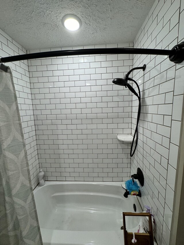 bathroom with a textured ceiling and shower / bath combination with curtain