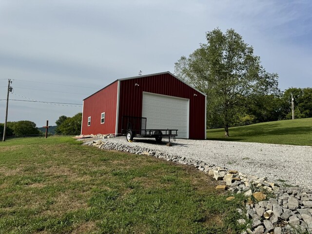 view of outdoor structure with a garage and a lawn