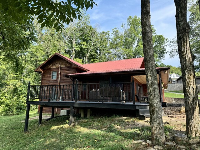 view of front of house featuring a front lawn and a wooden deck