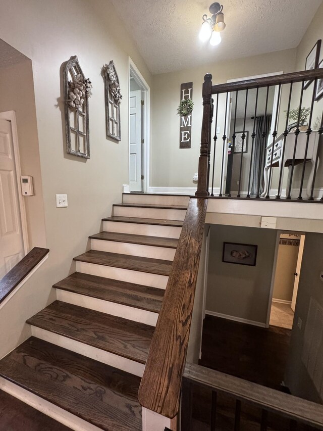 stairs featuring a textured ceiling