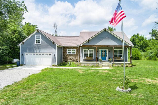 view of front of home with a garage, a front yard, and covered porch