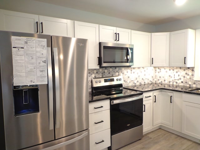 kitchen with backsplash, light hardwood / wood-style flooring, stainless steel appliances, and white cabinets