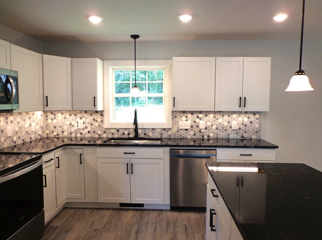 kitchen with pendant lighting, dark wood-type flooring, sink, white cabinetry, and appliances with stainless steel finishes