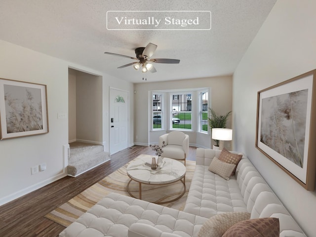 living room with hardwood / wood-style flooring, ceiling fan, and a textured ceiling