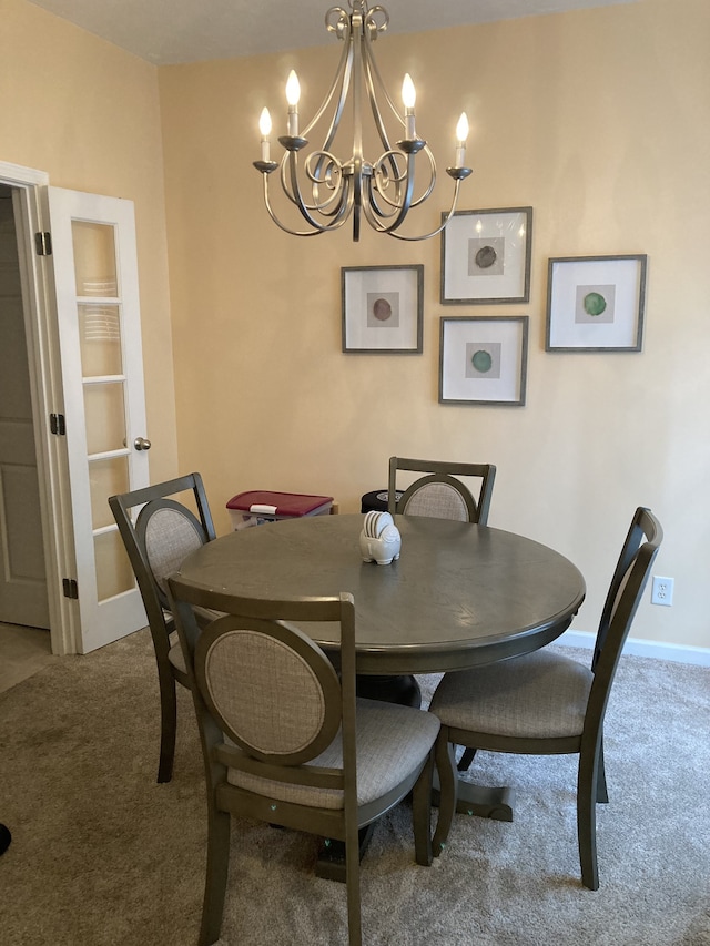 dining space featuring carpet flooring and a notable chandelier