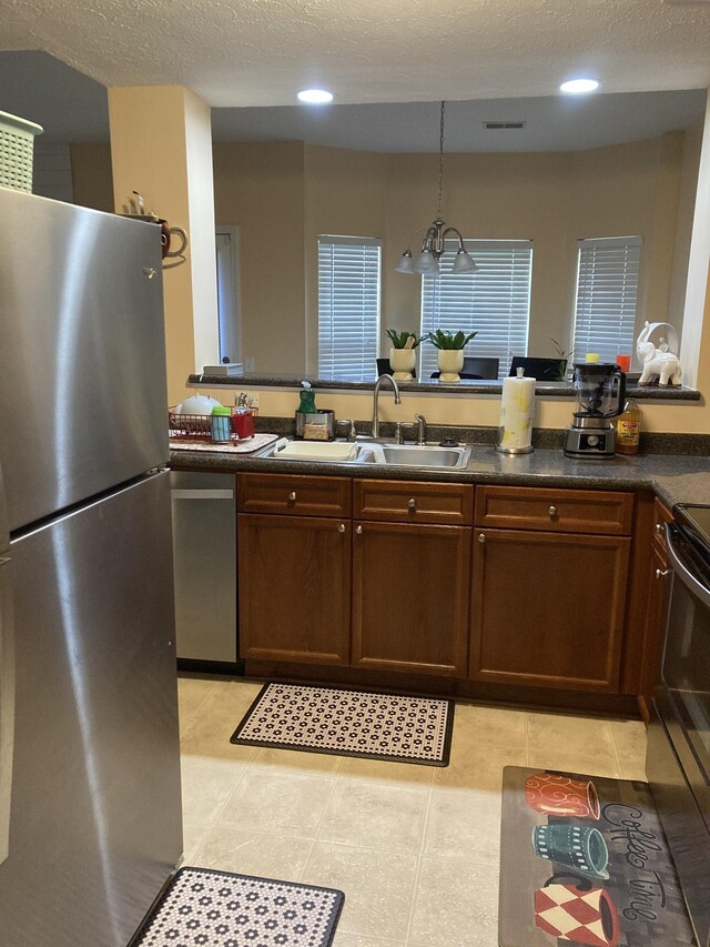 kitchen with sink, pendant lighting, stainless steel appliances, and light tile patterned floors