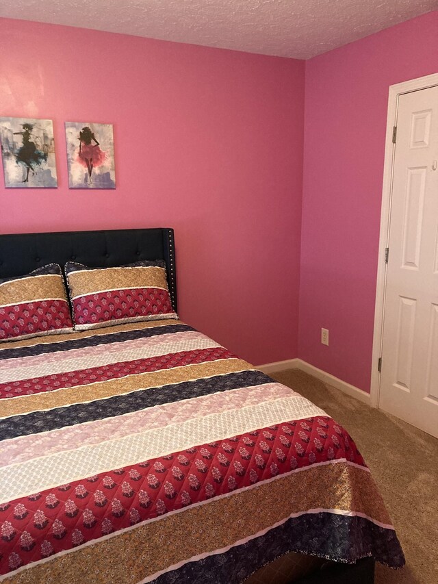 carpeted bedroom featuring a textured ceiling