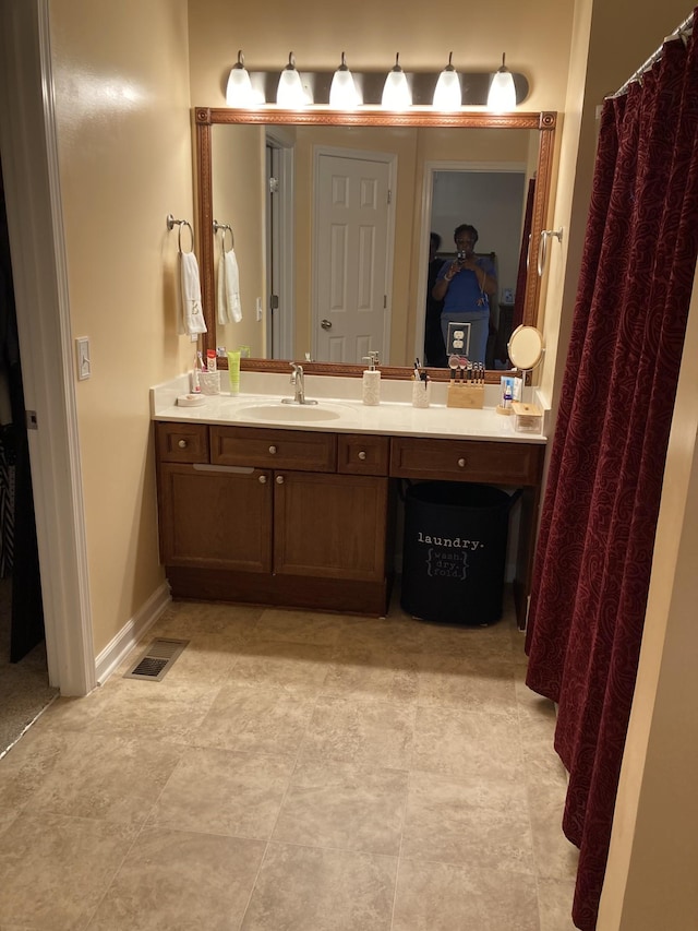 bathroom with baseboards, visible vents, and vanity