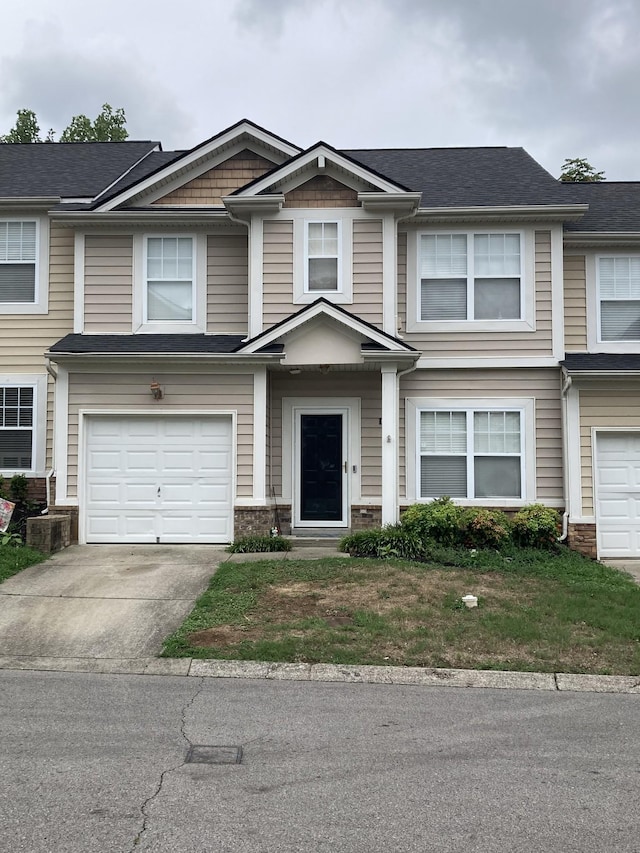 townhome / multi-family property featuring concrete driveway, brick siding, and an attached garage