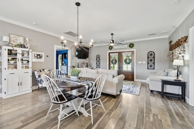 dining space featuring crown molding, hardwood / wood-style flooring, and french doors