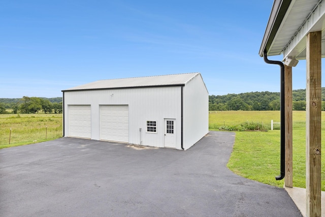 garage featuring a yard and a rural view