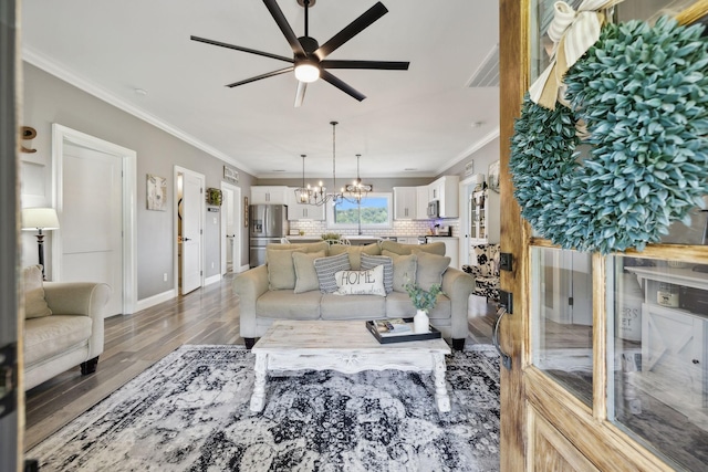 living room with hardwood / wood-style floors, ceiling fan with notable chandelier, and ornamental molding