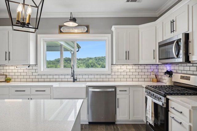 kitchen with white cabinetry, sink, decorative light fixtures, and stainless steel appliances