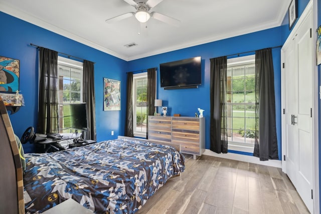 bedroom featuring ornamental molding, ceiling fan, and light hardwood / wood-style flooring