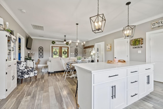 kitchen featuring white cabinetry, hanging light fixtures, and a kitchen island