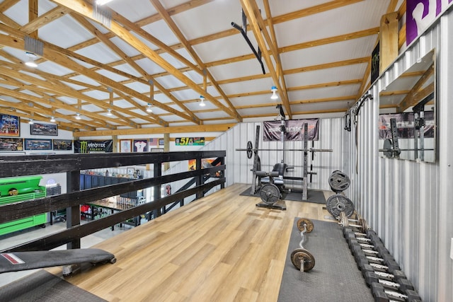 workout room featuring hardwood / wood-style flooring and vaulted ceiling