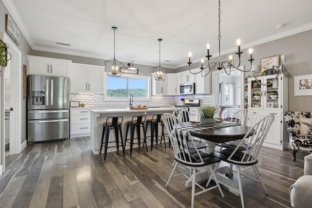 dining space with dark hardwood / wood-style flooring and ornamental molding