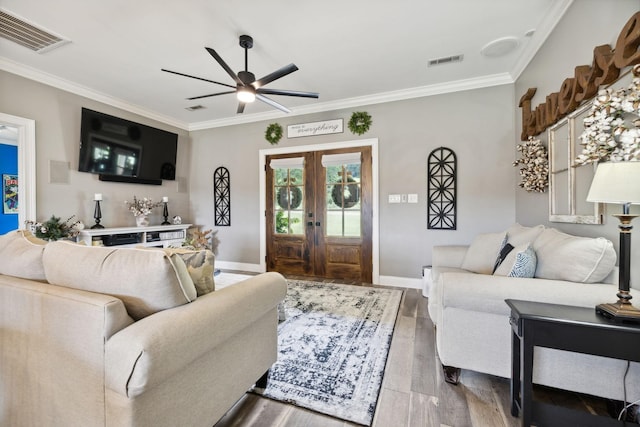 living room with crown molding, wood-type flooring, french doors, and ceiling fan