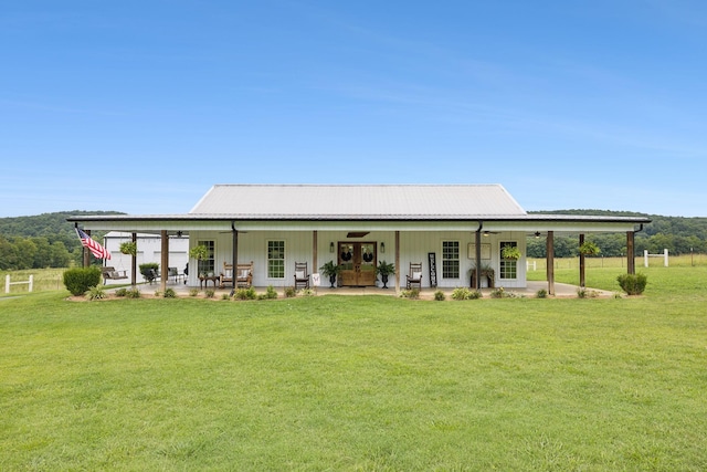 rear view of property with a porch and a yard