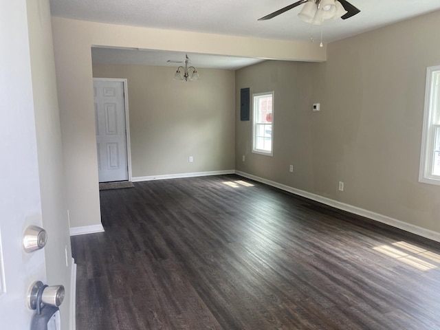 unfurnished room featuring dark wood-type flooring, baseboards, and ceiling fan with notable chandelier