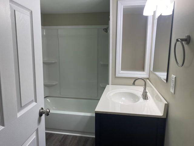 bathroom with tub / shower combination, wood finished floors, and vanity