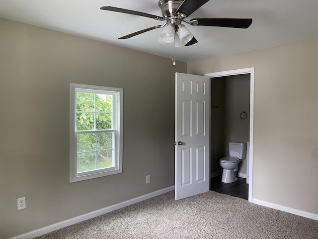 unfurnished bedroom with carpet floors, connected bathroom, a ceiling fan, and baseboards