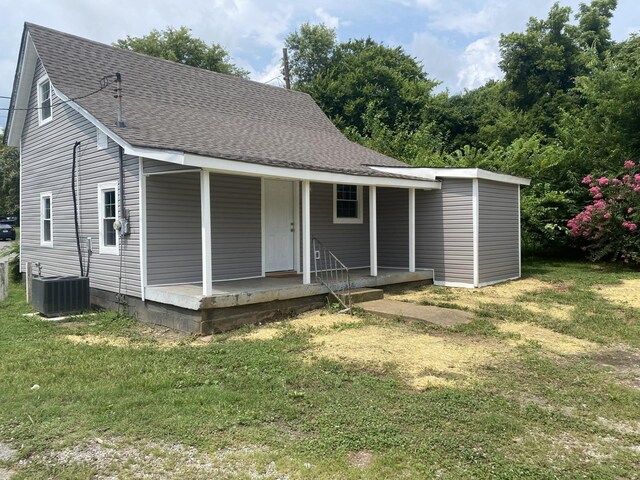 back of house with a porch, a lawn, and cooling unit