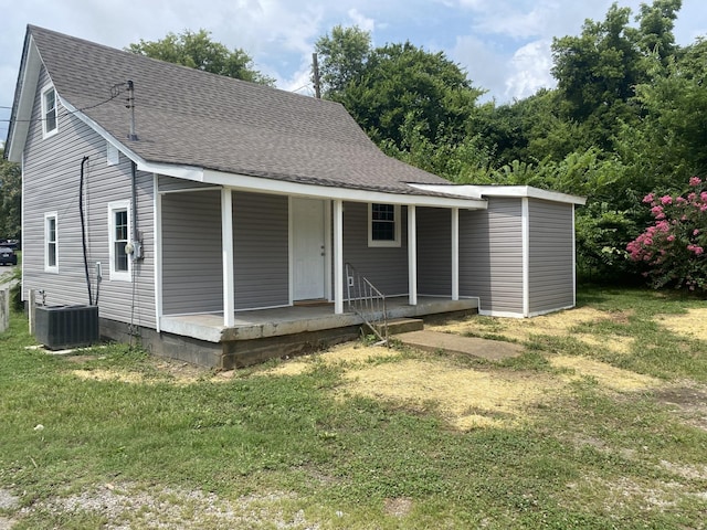 view of front of property featuring a porch, roof with shingles, a front yard, and central air condition unit