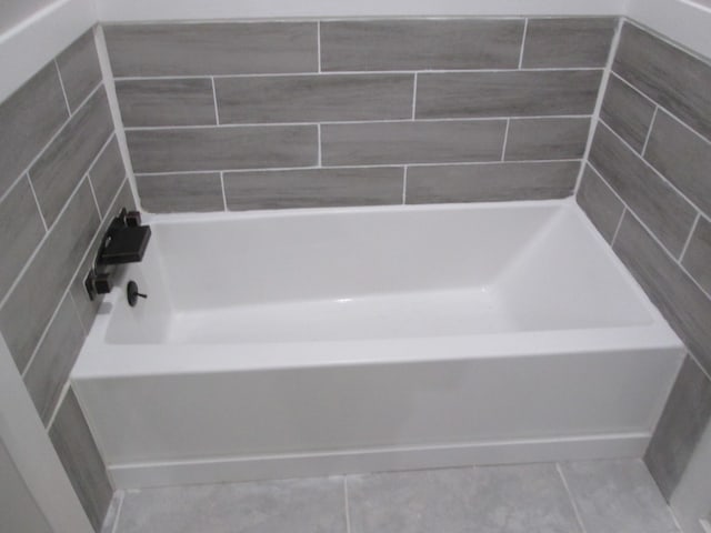 bathroom featuring a washtub and tile patterned floors