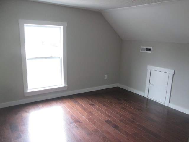 additional living space with dark hardwood / wood-style floors and vaulted ceiling