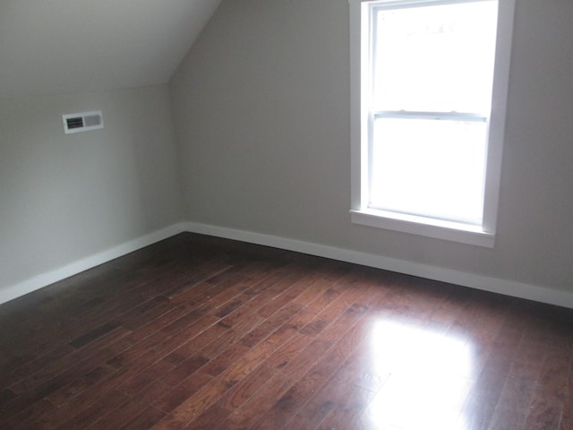 additional living space featuring vaulted ceiling and dark hardwood / wood-style floors