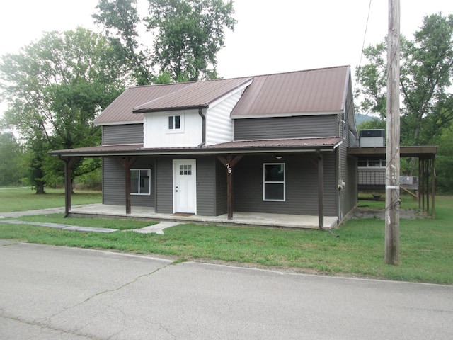 farmhouse-style home featuring a front yard and covered porch