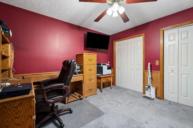 office space featuring ceiling fan, light carpet, and a textured ceiling