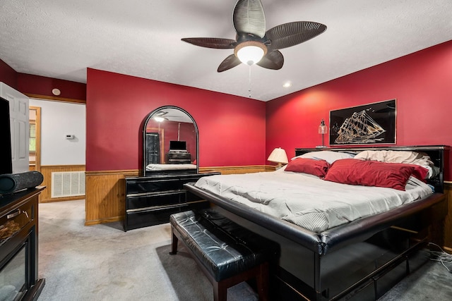 carpeted bedroom featuring ceiling fan and a textured ceiling