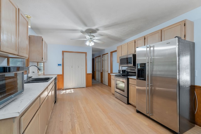 kitchen featuring sink, light wood-type flooring, light brown cabinets, ceiling fan, and stainless steel appliances