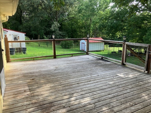 deck featuring a storage unit and a lawn