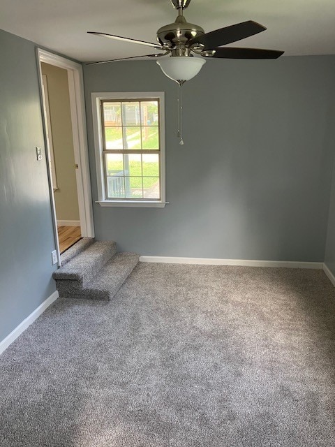 carpeted empty room featuring ceiling fan