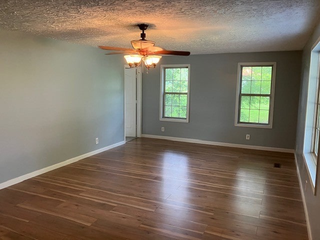 spare room featuring a textured ceiling, ceiling fan, and dark wood-type flooring