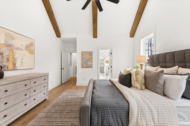 bedroom with light wood-type flooring, ensuite bathroom, ceiling fan, high vaulted ceiling, and beamed ceiling