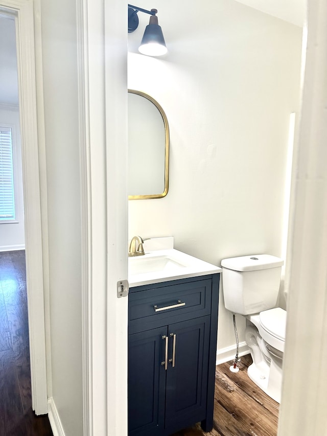 bathroom featuring vanity, hardwood / wood-style flooring, and toilet