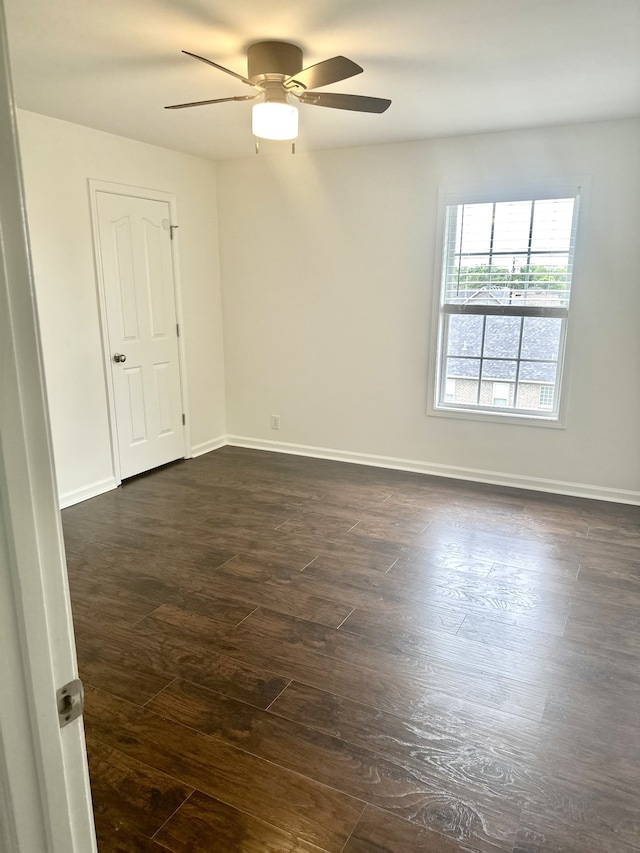 spare room with dark wood-type flooring and ceiling fan